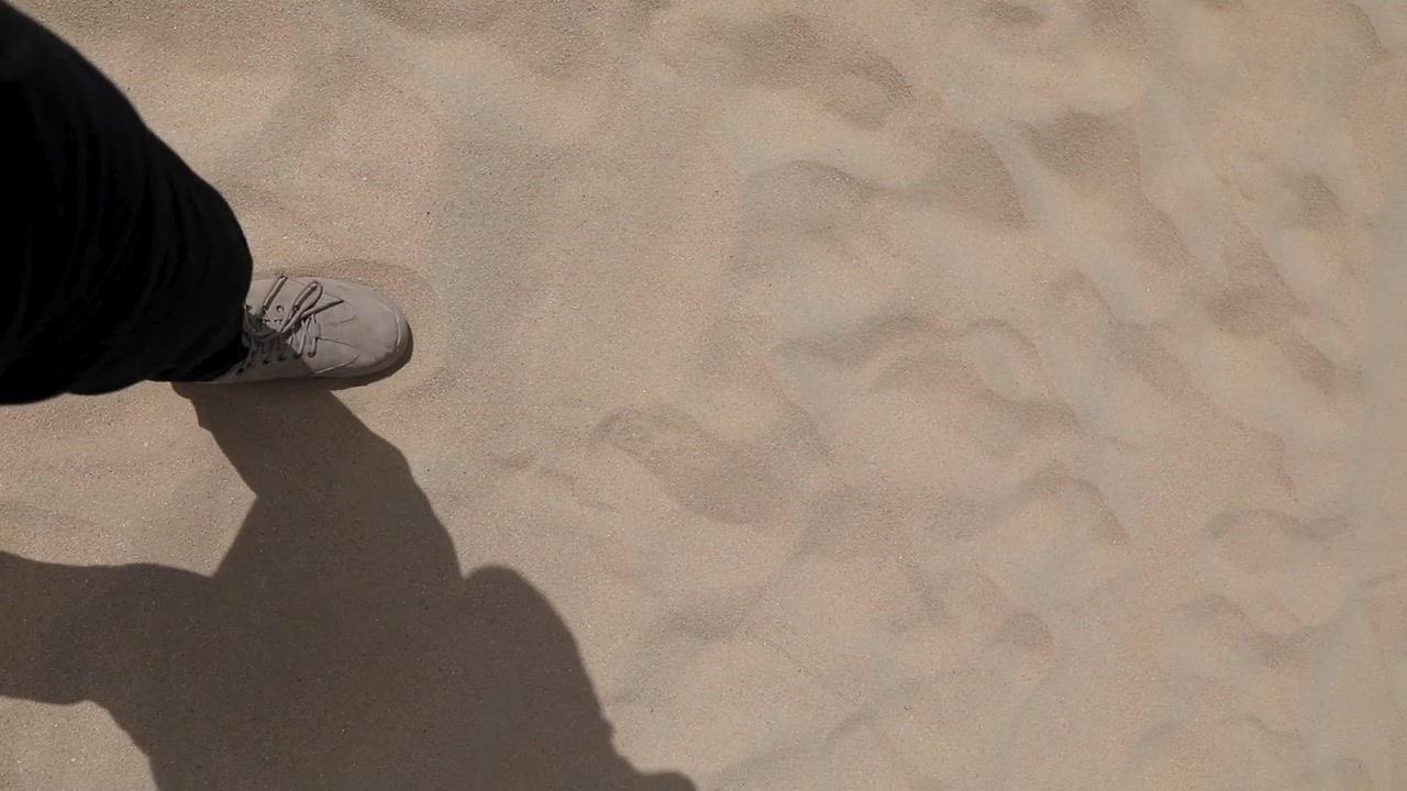 A man walking on footprints in the sands of the Egyptian desert under the scorching desert sun