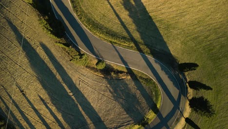 Descripción-General-De-Arriba-Hacia-Abajo-De-Largas-Sombras-Que-Cruzan-Campos-De-Cultivo-De-La-Campiña-Toscana-Y-Caminos-Sinuosos