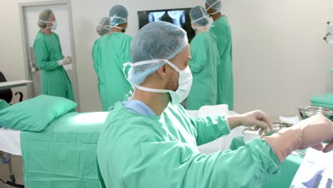 Diversos-Cirujanos-Usando-Batas-Quirúrgicas-Mirando-Exploraciones-De-Rayos-X-En-Quirófano,-Cámara-Lenta