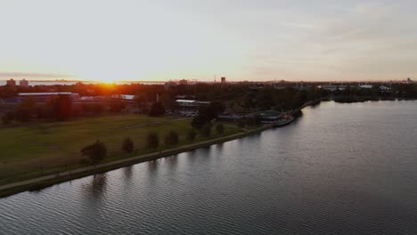 Aerial-pan-view-of-the-sun-setting-in-Albert-Park,-Melbourne,-Victoria