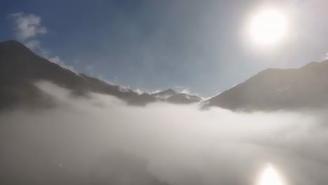 aerial view of mist-covered mountains in queenstown, new zealand, during sunrise. crisp winter air and clear skies enhance the serene atmosphere