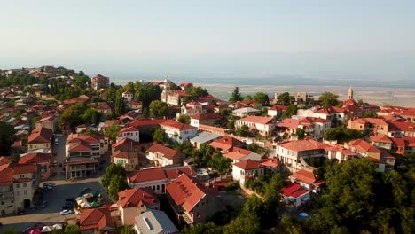 4k-Georgia-Kakheti-Sighnaghi-Luftaufnahme-über-Den-Hauptplatz,-Farbenfrohe,-Schöne-Orangefarbene-Ziegelschläuche---Gebäude-Und-Die-Wunderschöne-Architektur-Des-Kirchturms