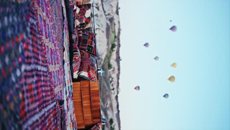 Rooftop-terrace-decorated-with-pillows-and-carpets-in-Turkish-style-with-the-view-of-hot-air-balloons-in-Cappadocia