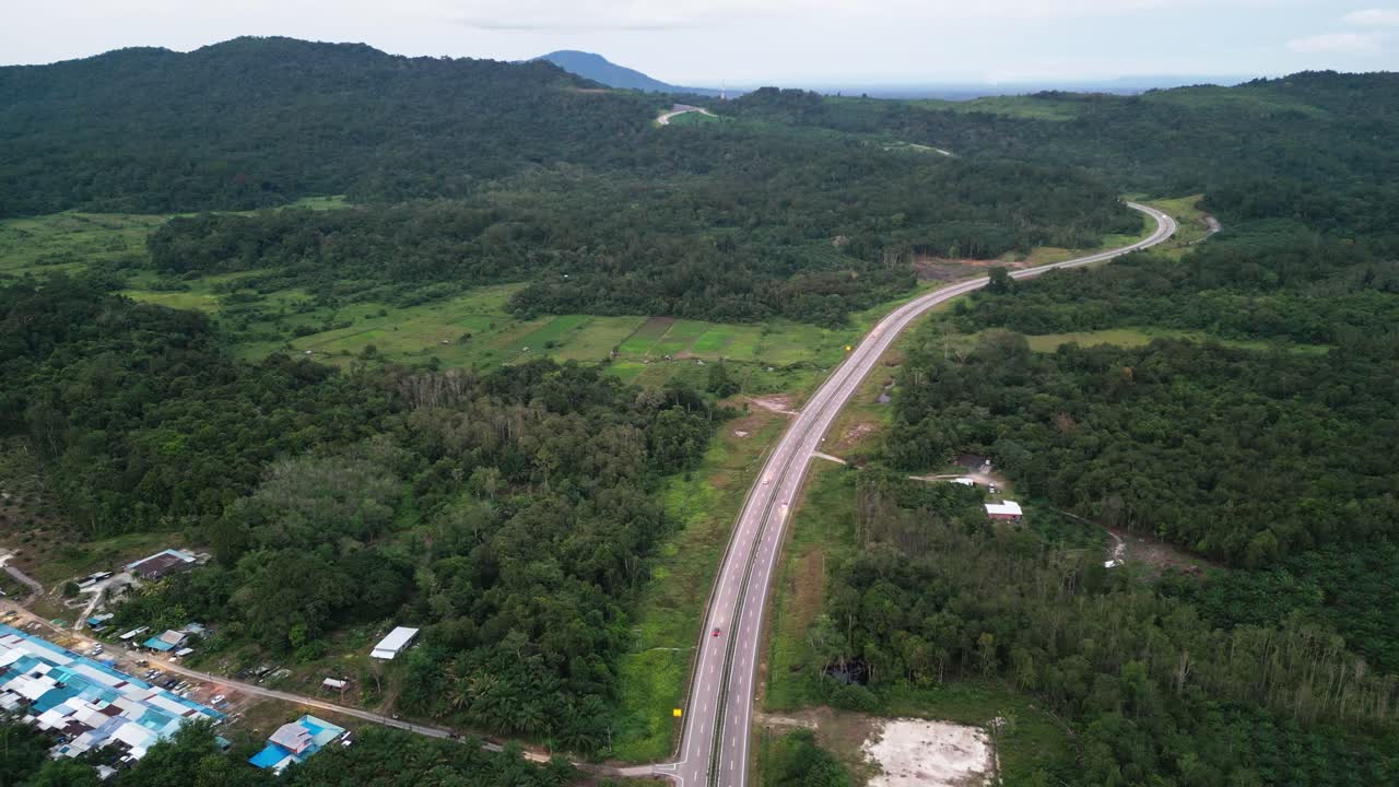 보르네오 고속도로에서 해가 지는 드론 뷰 저녁 녹색 숲과 산, 사라와크.