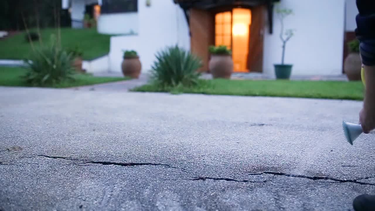 hombre regando grietas en el hormigón