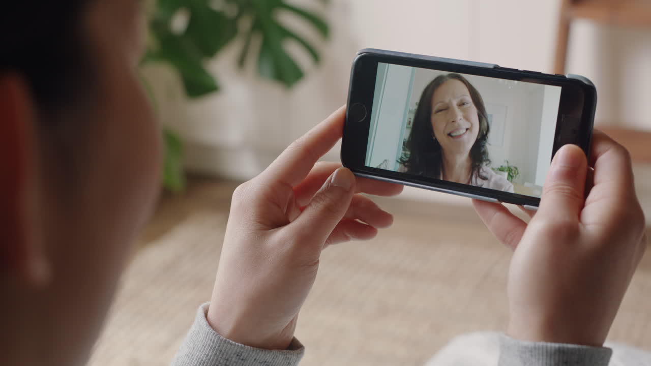 mujer joven teniendo video chat usando teléfono inteligente en casa hablando con su madre disfrutando de la conversación compartiendo estilo de vida en el teléfono móvil