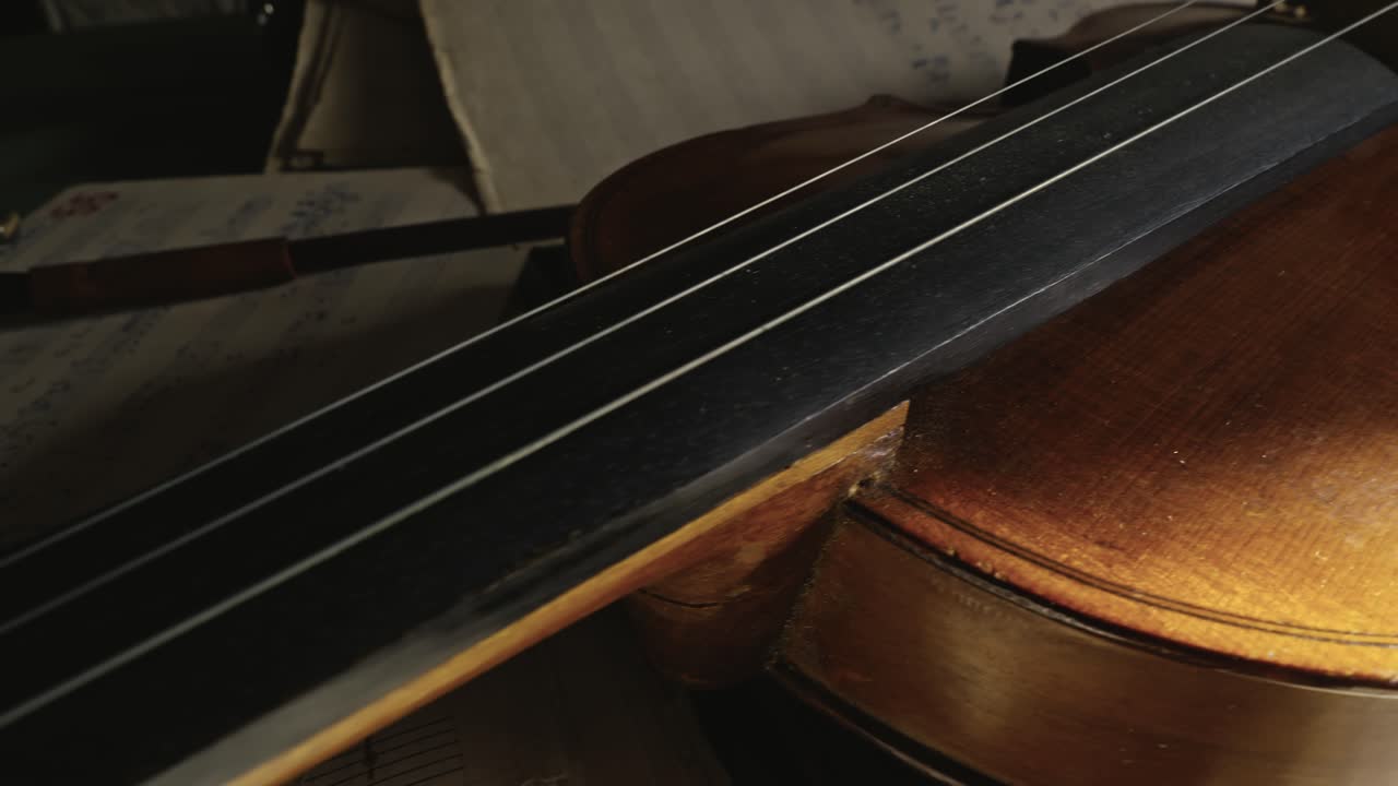 Aged violin with missing string lays on sheet music SLIDE reveal close-up