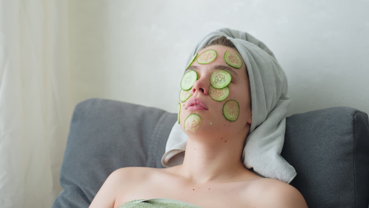 Close-up view of woman with cucumber slices placed on her face while relaxing, she enjoys a soothing self-care moment, feeling calm and rejuvenated with cucumber mask for skin refreshment