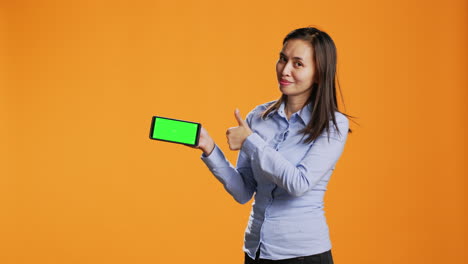 Confident-girl-shows-greenscreen-on-phone-display