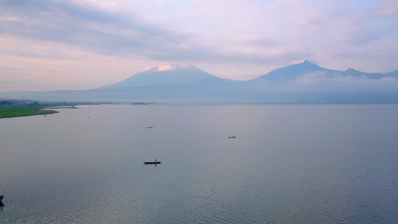 barcos rurales tradicionales cruzando el lago rawa pening en indonesia al atardecer