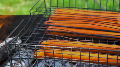 Cooking-meat-sausages-on-old-rusty-outdoor-BBQ-grill,-close-up-shot