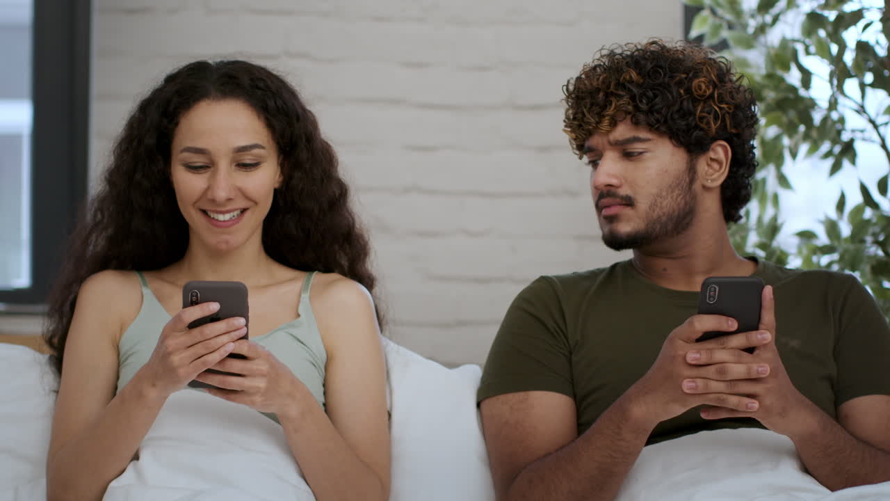 Couple in Bed Looking at Phones