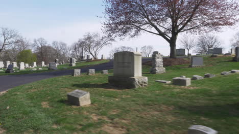 4k: driving slowly by old headstones through a cemetery on a beautiful day