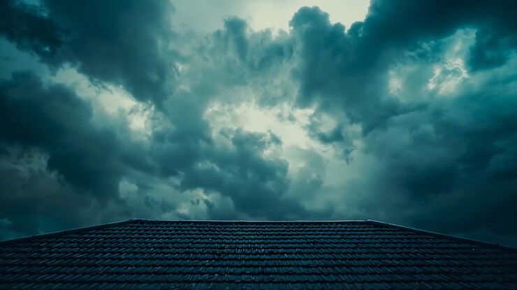 Camera tilting revealing severe storm clouds rolling above residential rooftop ridge