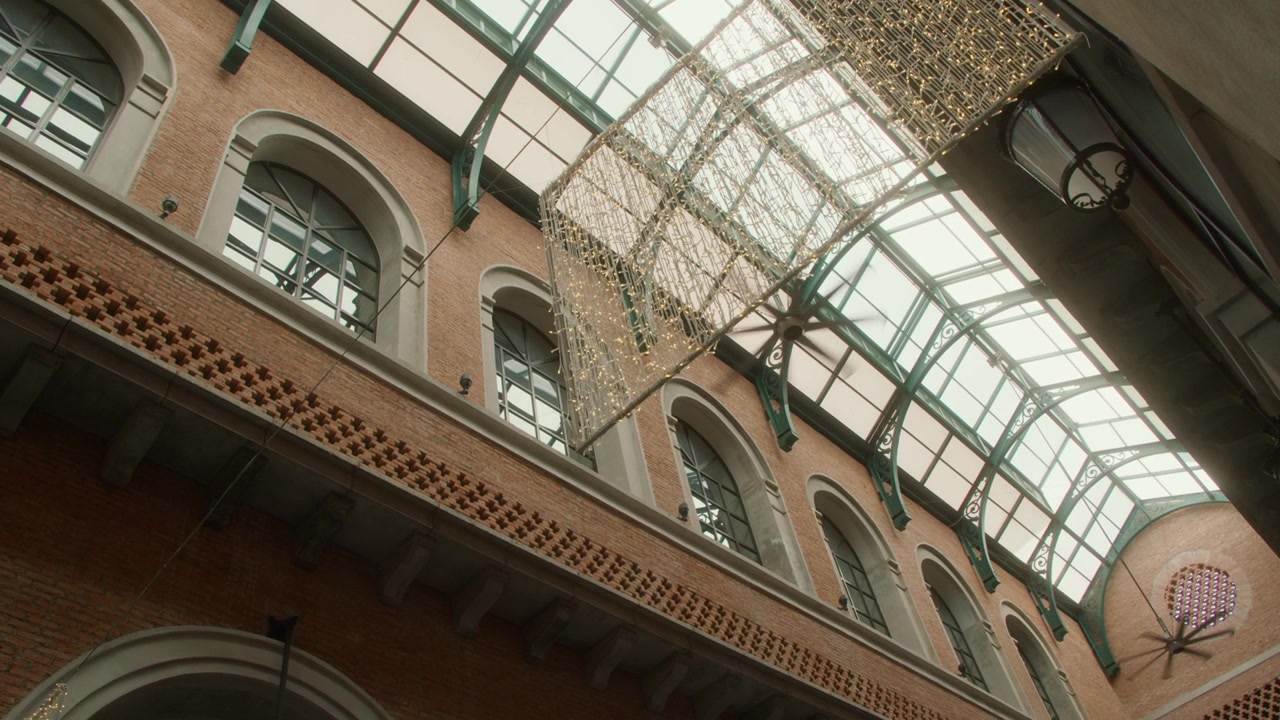 Vista dal basso dell'interno di un edificio in mattoni ornato con soffitto in vetro
