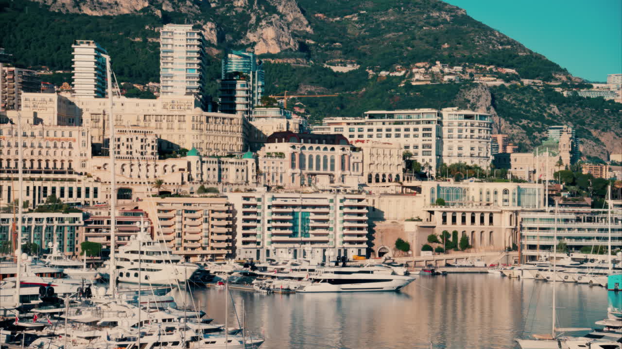 View of boats docked in the Monaco Marina with the skyline of the city on the background