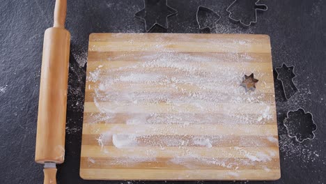 Flour-on-chopping-board-with-various-cookie-cutters-and-rolling-pin-4k