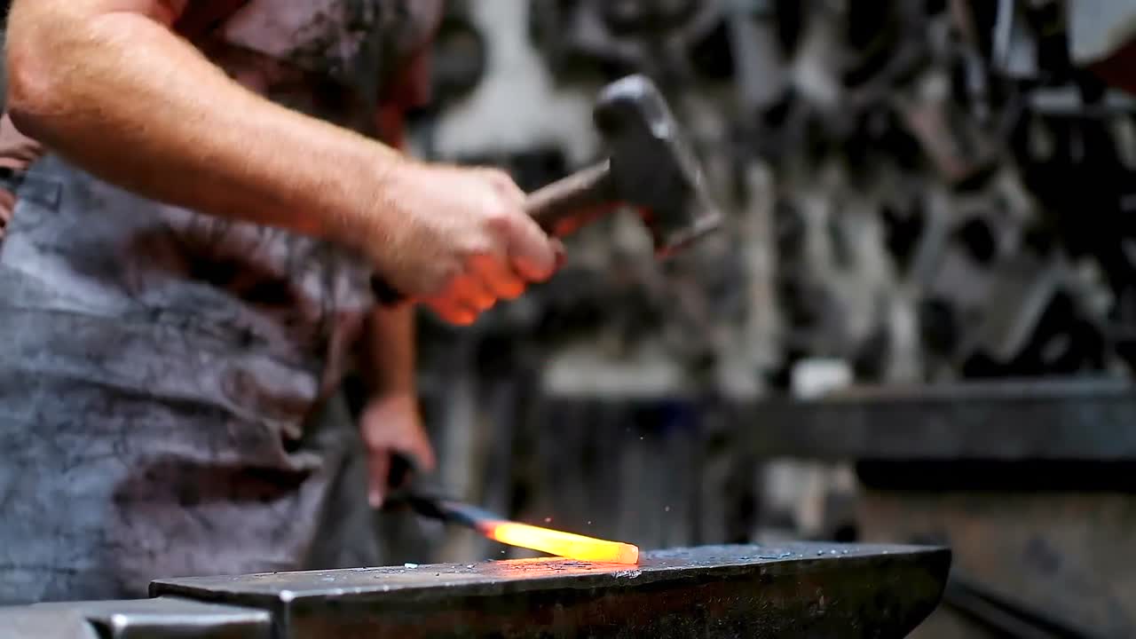 herrero forjando el metal fundido con martillo 4k