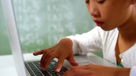 Schoolgirl-using-laptop-in-classroom