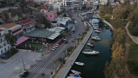 birds eye view shot in a small canal full of small yacht and a busy street view full of cars