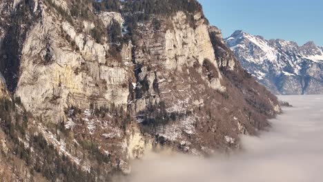 majestic mountain cliffs above a misty valley in amden, switzerland, on a clear day