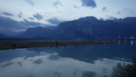 Vista-Aérea-Del-área-De-Conservación-De-Squamish-Spit-Canada,-Paisaje-Natural-De-Montañas-Con-Barco-Amarrado-En-El-Puerto-Iluminado-Por-La-Noche