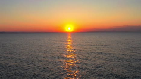 Aerial-drone-shot-of-Colorful-sunset-that-is-being-reflected-in-the-calm-sea-at-Findhorn-Beach-Scotland