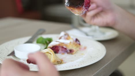 Unerkennbarer-Mann-Im-Weißen-T-Shirt,-Der-Im-Restaurant-Mit-Gabel-Und-Messer-Wüstenstrudel-Isst.-Zeitlupenaufnahme