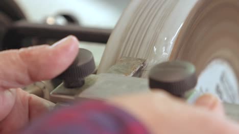 A-close-up-shot-of-carpenter-sharpening-a-Chisel-on-a-Whetstone-in-Slow-motion