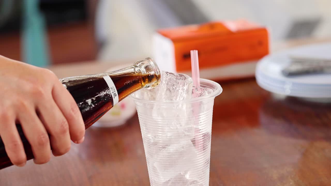 얼음으로 가득 찬 컵에 어두운 소다를 부는 순서