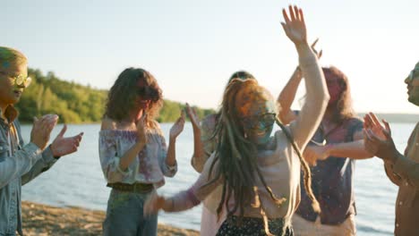 slow motion of cute girl with dreads dancing at holi festival with friends enjoying beach party