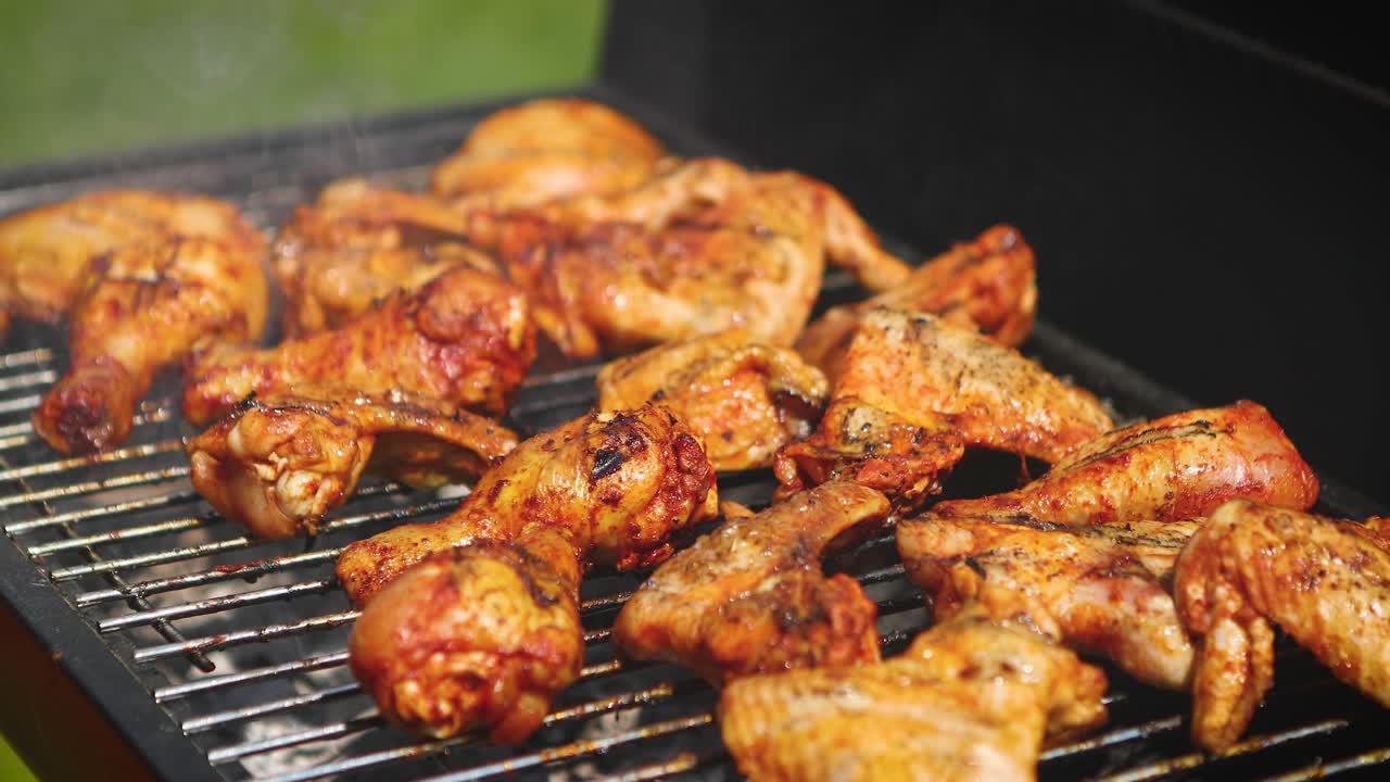 Delicious chicken pieces frying on barbecue grill