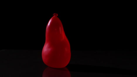 red water balloon falling on black background