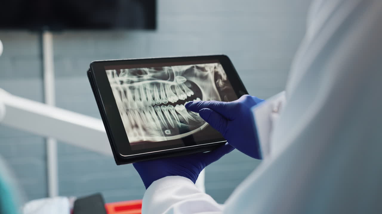 Dentist analyzing dental x-ray on a tablet