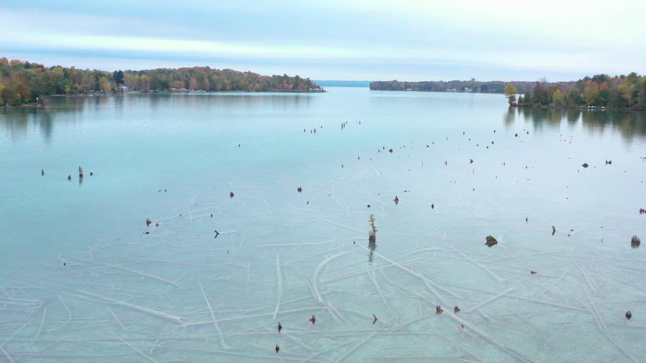 4K Drone Circle around wood in lake in Autumn
