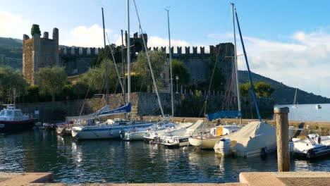 escena del puerto del castillo medieval en torri del benaco, lago de garda - lago de como - italia