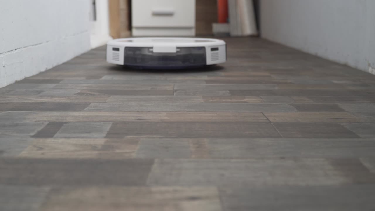 el robot aspirador automático se mueve a lo largo de su trayectoria. robot aspirador limpieza automática en el hogar. casa inteligente. moderno aspirador robótico limpia el piso. toma de primer plano. tecnologías modernas
