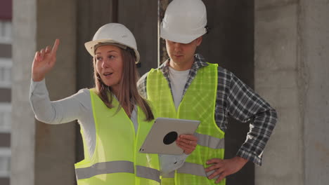 construction site team or architect and builder or worker with helmets discuss on a scaffold construction plan or blueprint or checklist