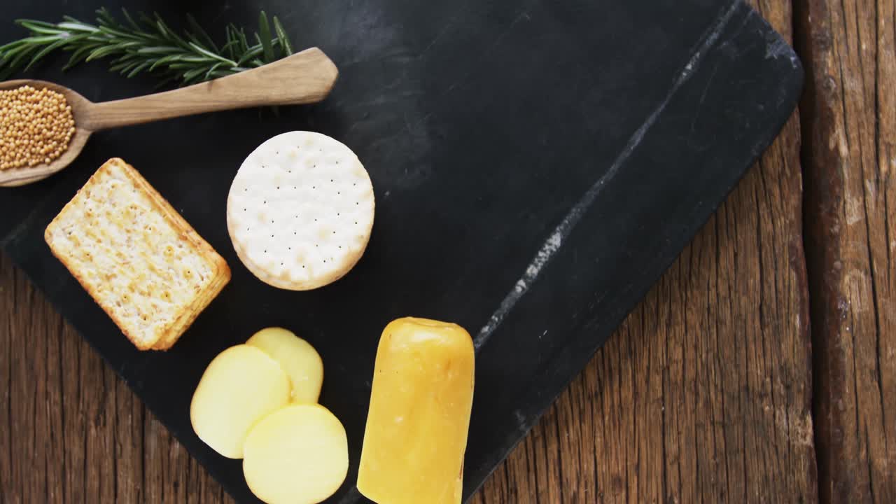 queso en rebanadas con galletas crujientes, semillas, hierba de romero y salsa