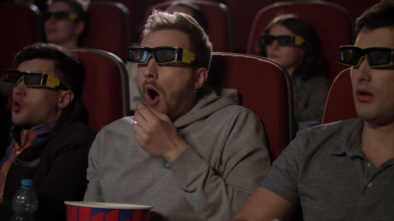 personas con gafas 3d en el cine. hombre con gafas 3d comer palomitas de maíz