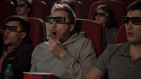 people in 3d glasses at cinema. man in 3d glasses eat pop corn