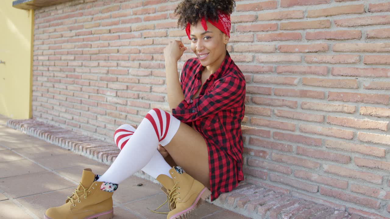 una joven elegante y pensativa sentada en el suelo