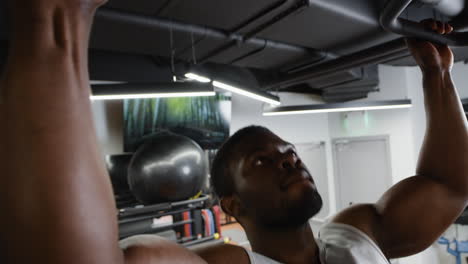 hombre realizando pull-ups en un gimnasio