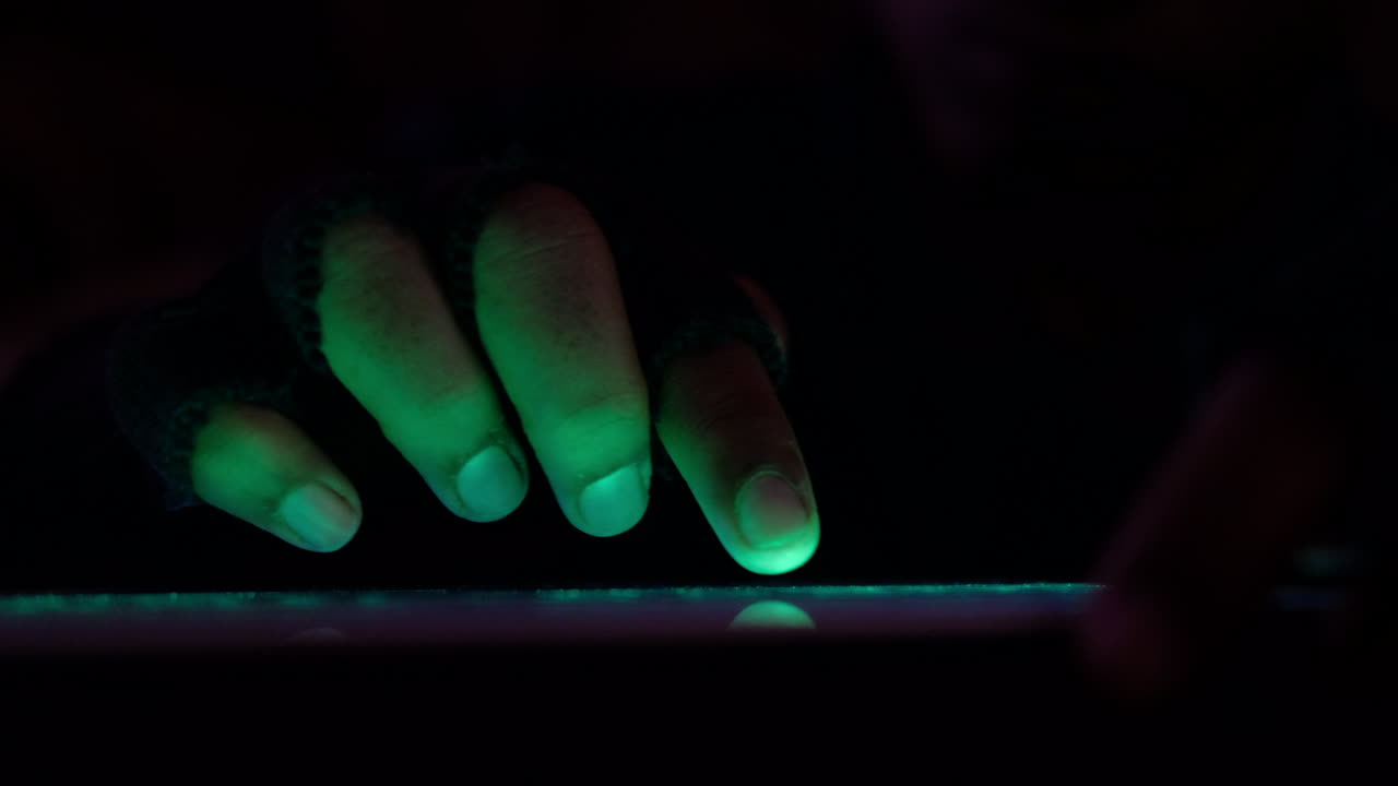 밤에 빛나는 녹색 화면을 사용하는 사람