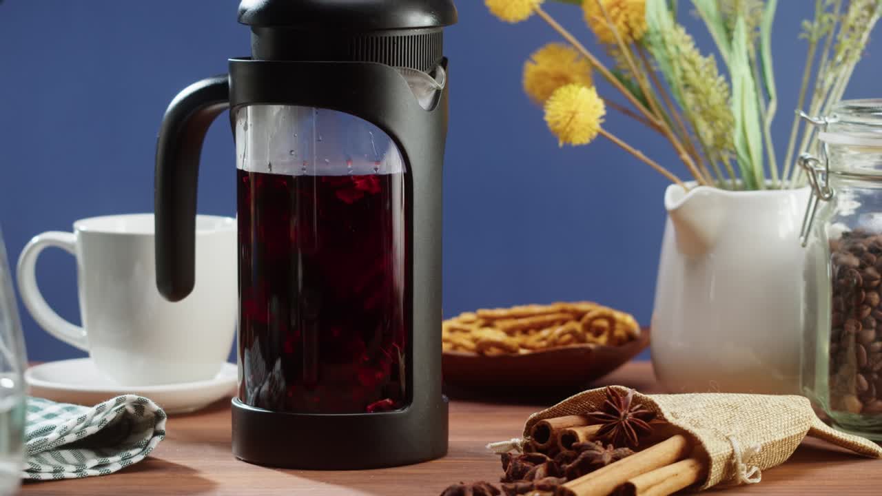 Brewing black tea in a teapot close-up. Drinking hot herbal drink on blue background