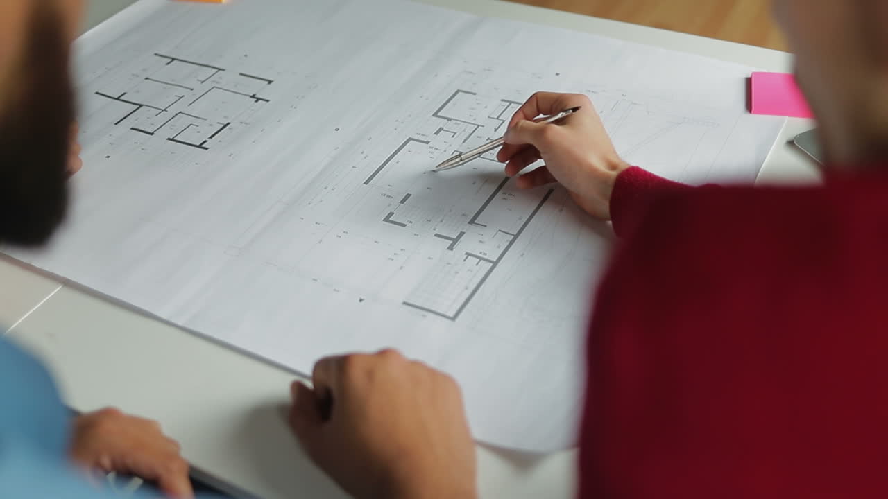 vista trasera de personas estudiando nuevos planos en la oficina.