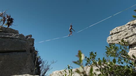 gimbal shot of men on a slackline on top of a mountain in slow motion