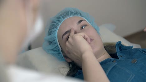 una señora habla con un cosmetólogo sobre un nuevo estilo de cejas.