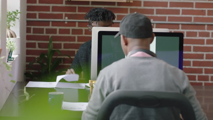 raer view african american businessman using computer typing corporate project browsing research study on screen in office workplace