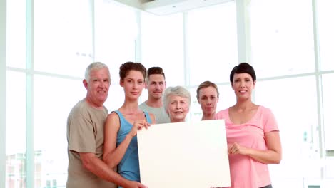 clase de fitness sosteniendo un póster blanco un aplauso
